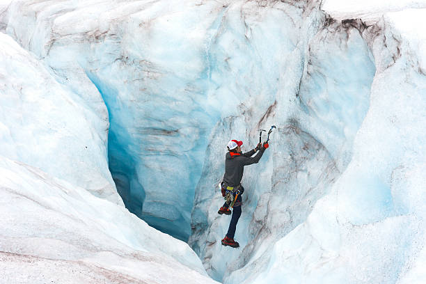 istock Man descends a giant moulin on a glacier 607488186