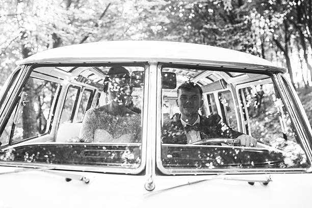 istock bride and groom sitting in the car 607492174