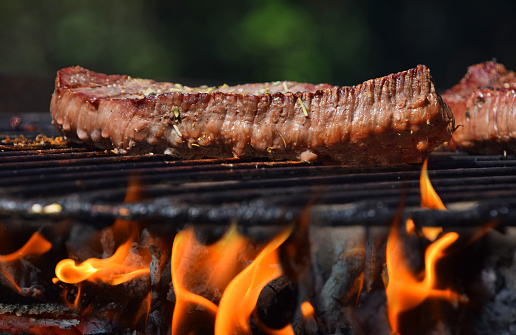 Beef steak barbecue prepared grilled on bbq open fire flame grill
