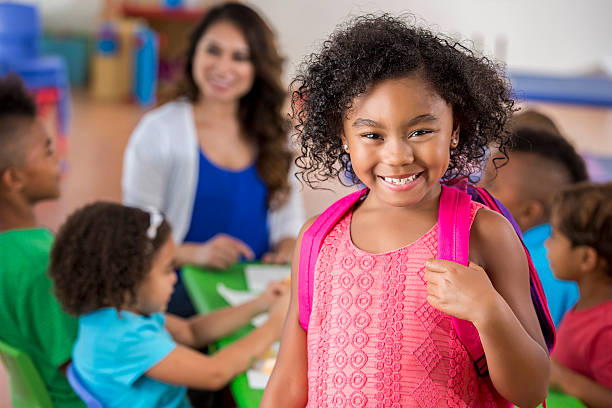 istock Confident schoolgirl smiles in classroom 607493690
