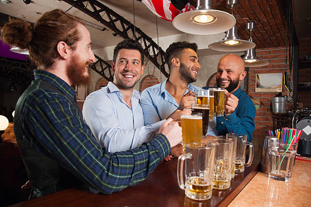 istock Man Group In Bar Hold Glasses Talking, Drinking Beer Mugs 607493710