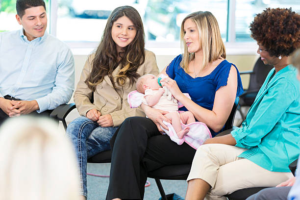 istock Beautiful mother holds infant while participating in group therapy 607494860
