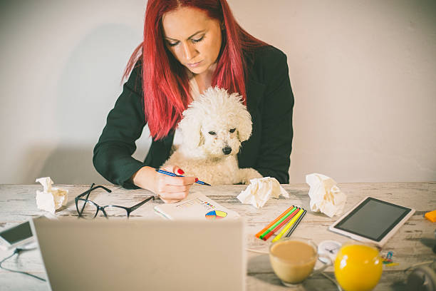istock working at home office and holding her puppy 607494872