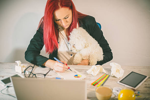 istock working at home office and holding her puppy 607494970