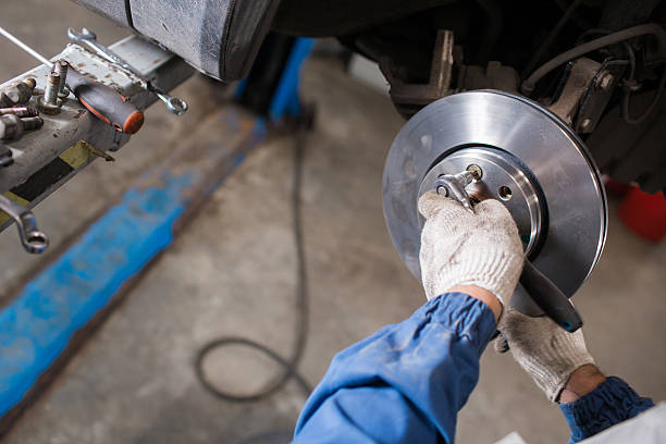 istock Brand new brake disc on car in a garage. Auto 607496228