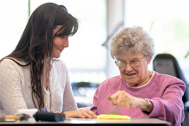 istock Elderly woman smiles as she makes progress in therapy 607497392