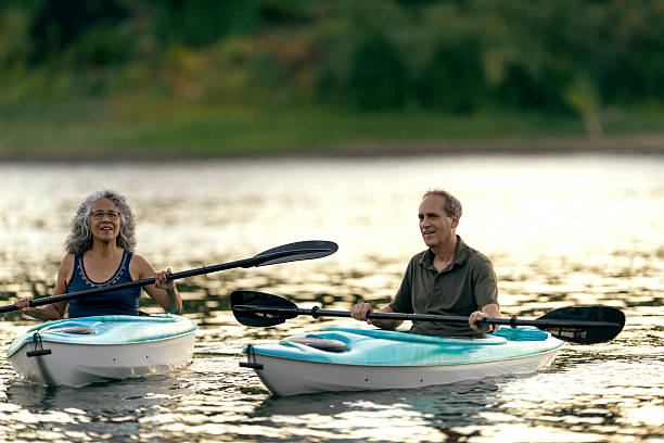 istock Cute elderly diverse couple kayaking together on the river 607499450