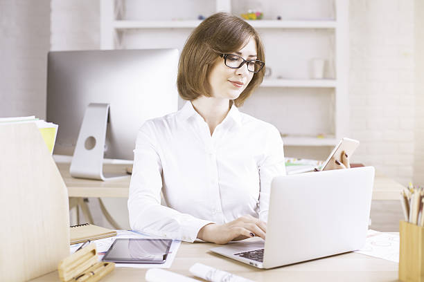 istock Woman using laptop and phone 607499788