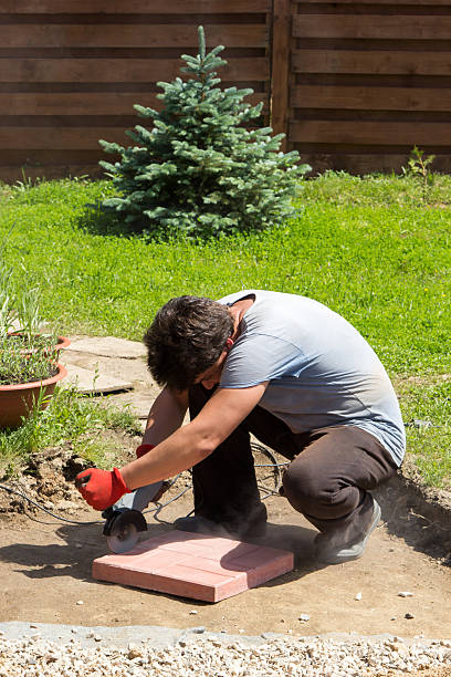 istock man cut red concrete paving slabs 607500680