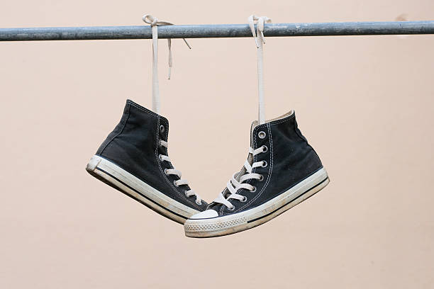 istock Black sneakers hanging on metal bar 607501424