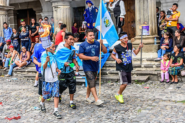 Runners with torches & flags, Independence Day, Antigua, Guatema Antigua, Guatemala - September 14, 2015: Locals run in streets with Guatemalan flags & lit torches while blowing whistles during Guatemalan Independence Day celebrations puerto quetzal guatemala stock pictures, royalty-free photos & images