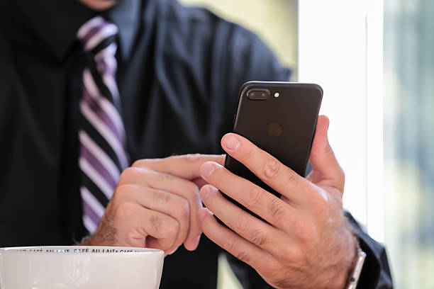 uomo in possesso di iphone 7 plus nero in caffetteria - ipad human hand men apple computers foto e immagini stock
