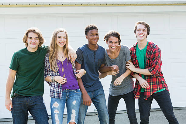 istock Group of five multi-ethnic teenagers hanging out 607505272