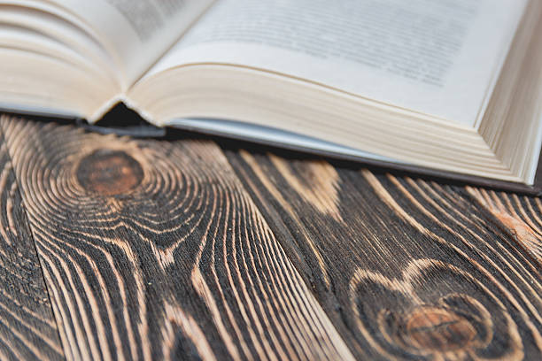 istock Open Book on Wooden Desk Close up. 607505808