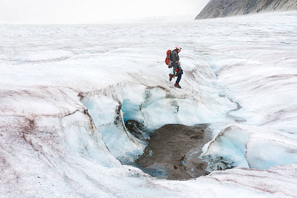 istock Man approaches glacial pit of mineral mud 607506598