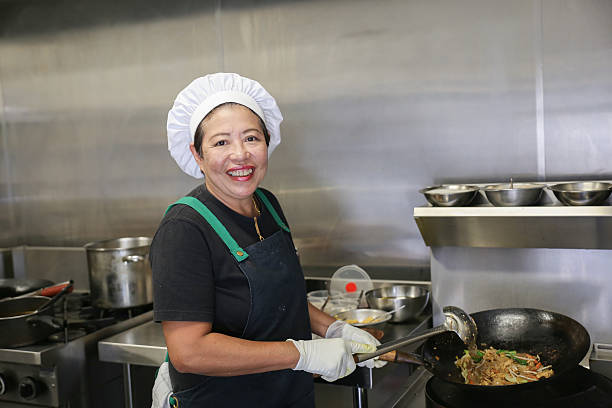พ่อครัวหญิงเอเชียในห้องครัว