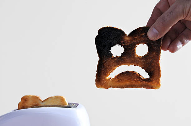 istock Hand holds one slices of burnt toast 607583790