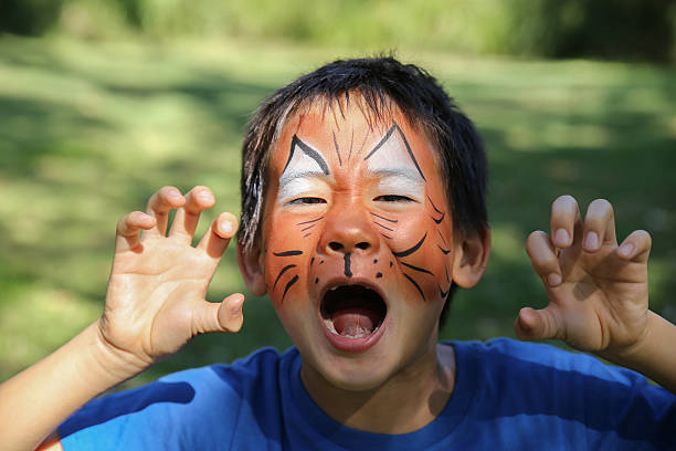 ragazzo con divertente pittura del viso come una tigre - face paint child animal little boys foto e immagini stock