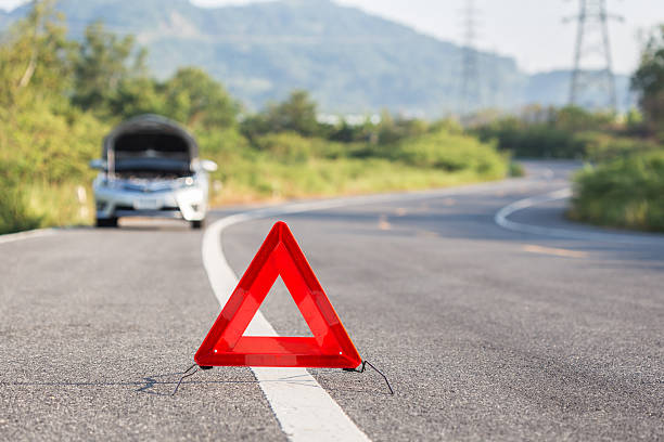 istock Red emergency stop sign and broken car on the road 607589762