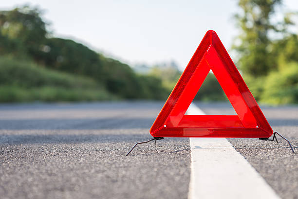 istock Red emergency stop sign and broken car on the road 607589806