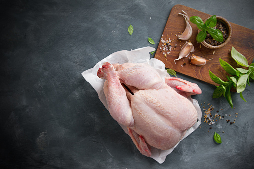 Fresh chicken with spices on vintage background with copyspace, selective focus. Healthy food, diet or cooking concept