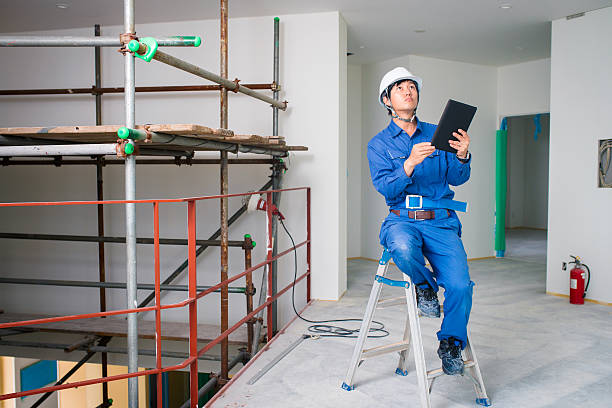 istock Construction worker sitting on a ladder whilst inspecting a site 607596804