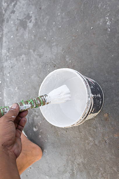 istock Painting walls.Painter paints using a brush 607597250