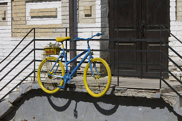 Yellow wall with bicycle parking sign and a metal structure for closing the lock on the bike to guard it in front of the shopping center
