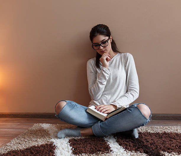 istock Young female reading a book 607599980