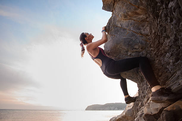 istock Young female rock climber climbing challenging route on overhanging cliff 607600656