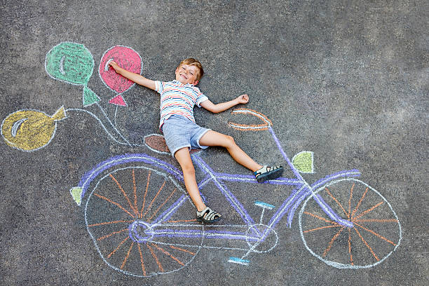 istock little kid boy having fun with bike chalks picture 607602578
