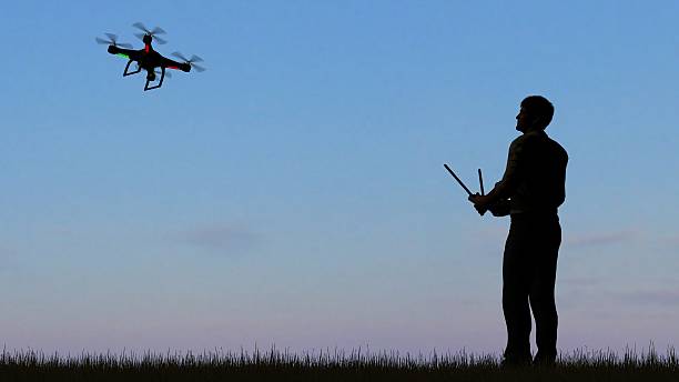 istock man operating of flying drone quadrocopter UAV at sunset 607603090