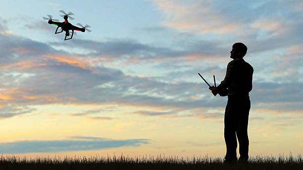 istock man operating of flying drone quadrocopter UAV at sunset 607603144