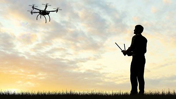 istock man operating of flying drone  UAV at sunset 607603196