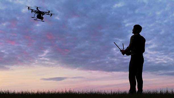 istock man operating of flying drone multicopter UAV at sunset 607603384