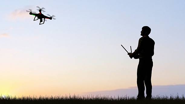 istock man operating of flying drone quadrocopter UAV at sunset 607603662