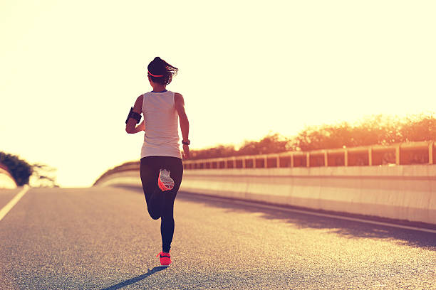 istock young woman runner running on city bridge road 607603790