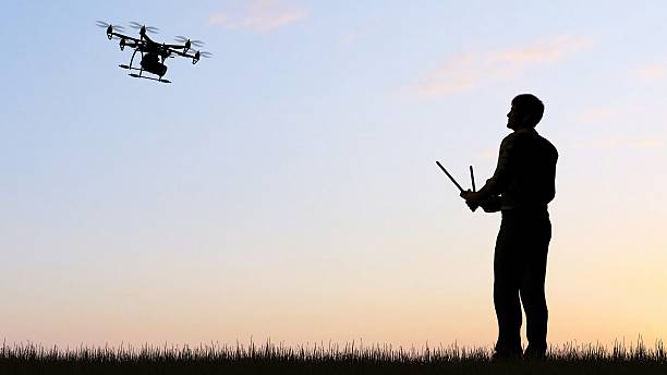istock man operating of flying drone multicopter UAV at sunset 607603858