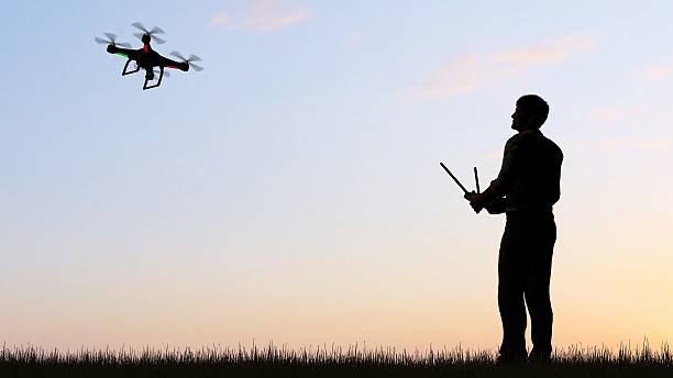 istock man operating of flying drone quadrocopter UAV at sunset 607603896