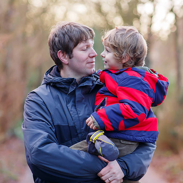 istock Happy father with his son on arm outdoors 607605080