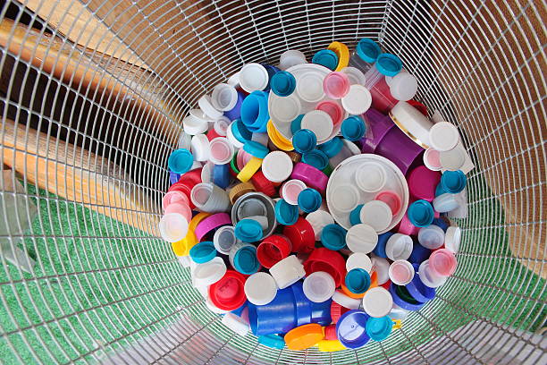 Colorful plastic caps collected in a recycle container stock photo