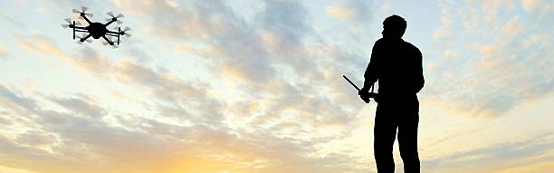 istock man operating of flying drone multicopter UAV at sunset 607605324