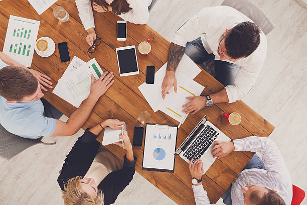 istock Group of busy business people working in office, top view 607605364