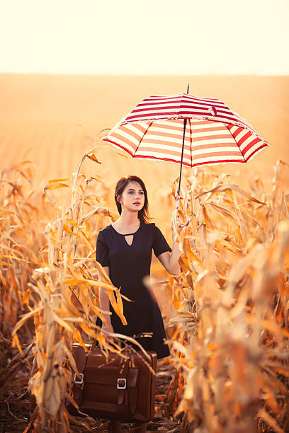 młoda kobieta z walizki i parasol - autumn clothing corn crop fashion zdjęcia i obrazy z banku zdjęć