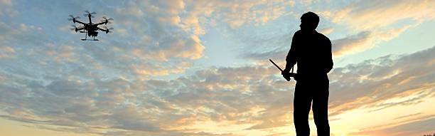 istock man operating of flying drone multicopter UAV at sunset 607605594