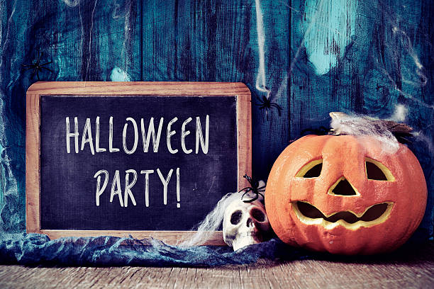 istock skull, pumpkin and text Halloween party in a chalkboard 607608636