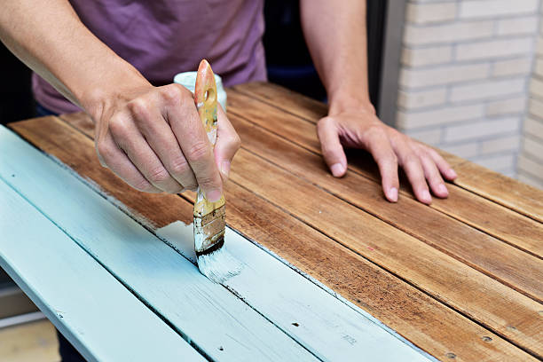 istock young man painting an old wooden table 607608788