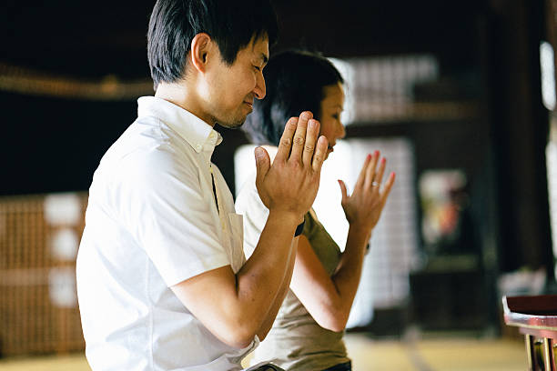 Japanese couple praying in a buddhist temple