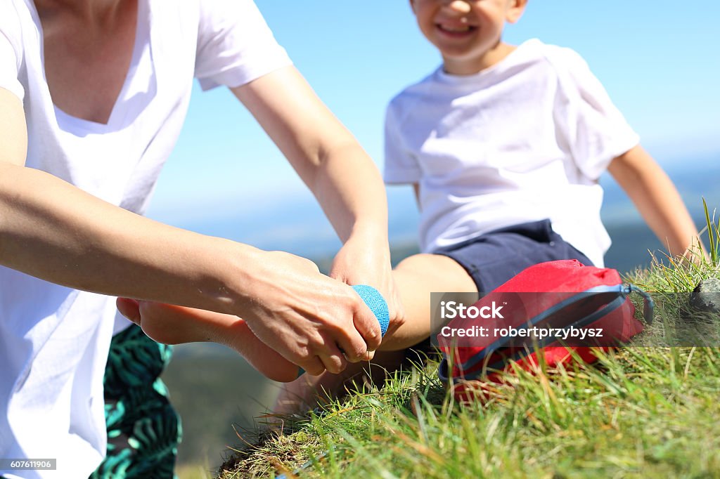 First aid, twisted leg. Child twisted his ankle during a mountain tour. Wound broken leg. First Aid Kit Stock Photo