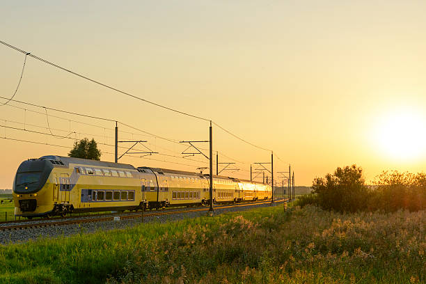 intercity train of the dutch railways driving past during sunset - ns stockfoto's en -beelden